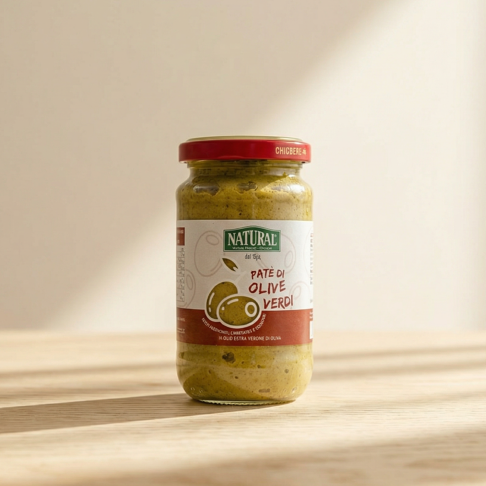 Jar of olive spread with a visible label on a wooden surface