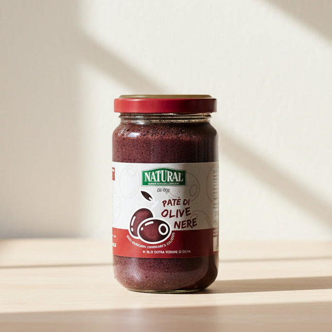 Jar of olive pate with a red lid on a kitchen environment