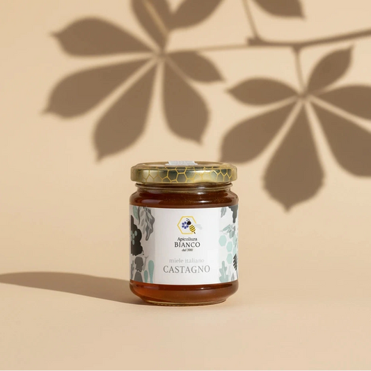 Jar of chestnut honey with a decorative label on a artistic background