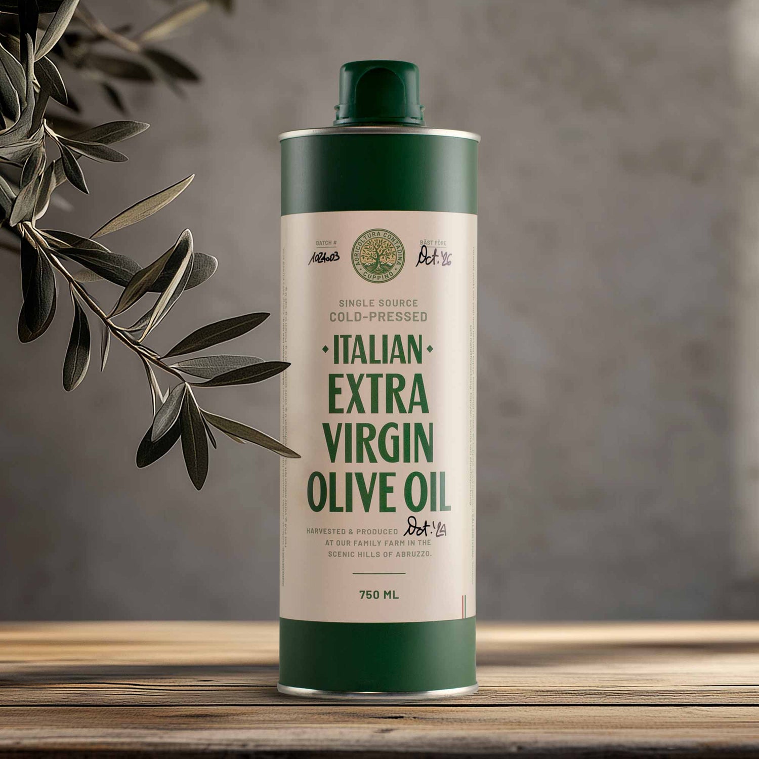 A 750ml bottle of Cuppino Extra Virgin Olive Oil with a green cap and label, placed on a wooden surface with olive leaves in the background.