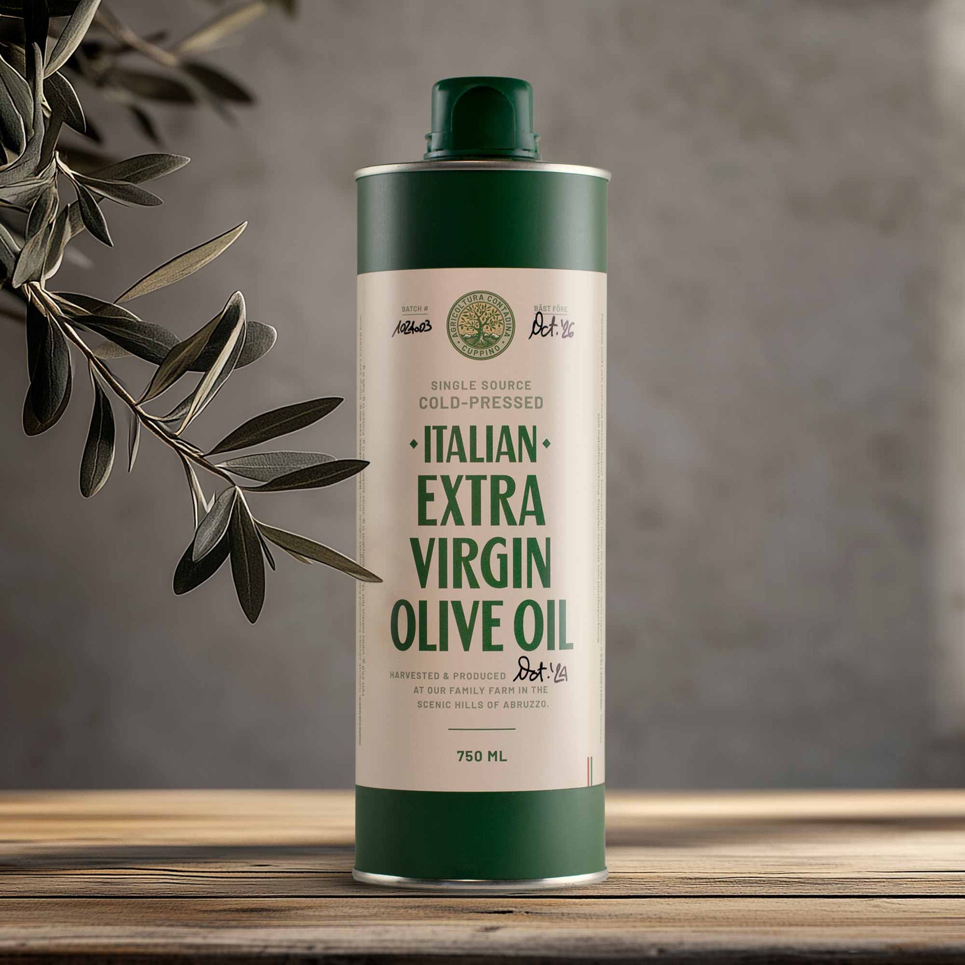 A 750ml bottle of Cuppino Extra Virgin Olive Oil with a green cap and label, placed on a wooden surface with olive leaves in the background.