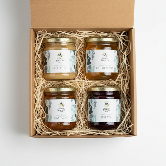 Four jars of different types of honey with labels on a white background