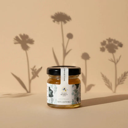 Small jar of wildflower honey with a label on a artistic background